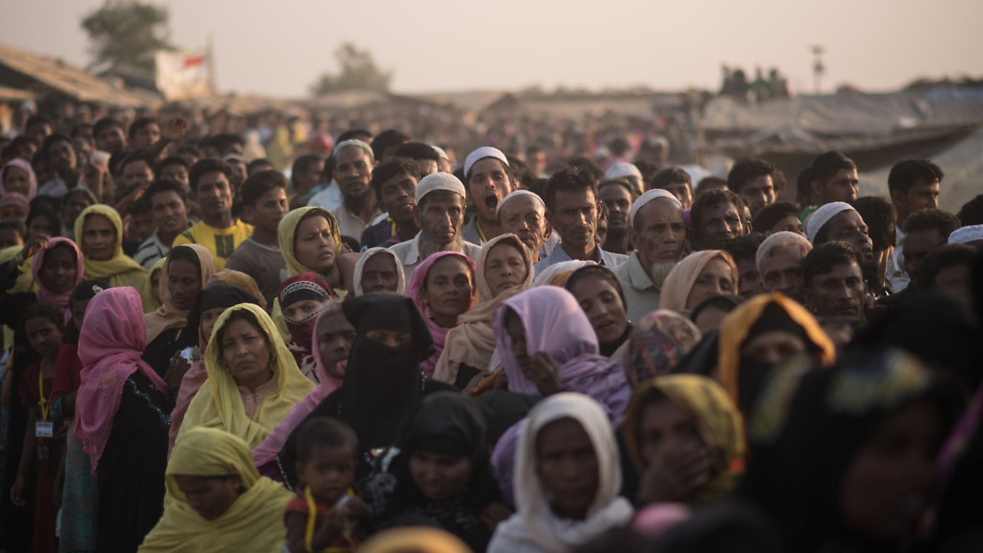 Rohingya Muslim refugees wait to be called to recieve food aid of rice, water, and cooking oil in a relief centre at the Kutupalong refugee camp in Cox's Bazar on November 28, 2017.
Rohingya are still fleeing into Bangladesh even after an agreement was signed with Myanmar to repatriate hundreds of thousands of the Muslim minority displaced along the border, officials said on November 27.  / AFP PHOTO / Ed JONES        (Photo credit should read ED JONES/AFP/Getty Images) - Credit: AFP/Getty Images