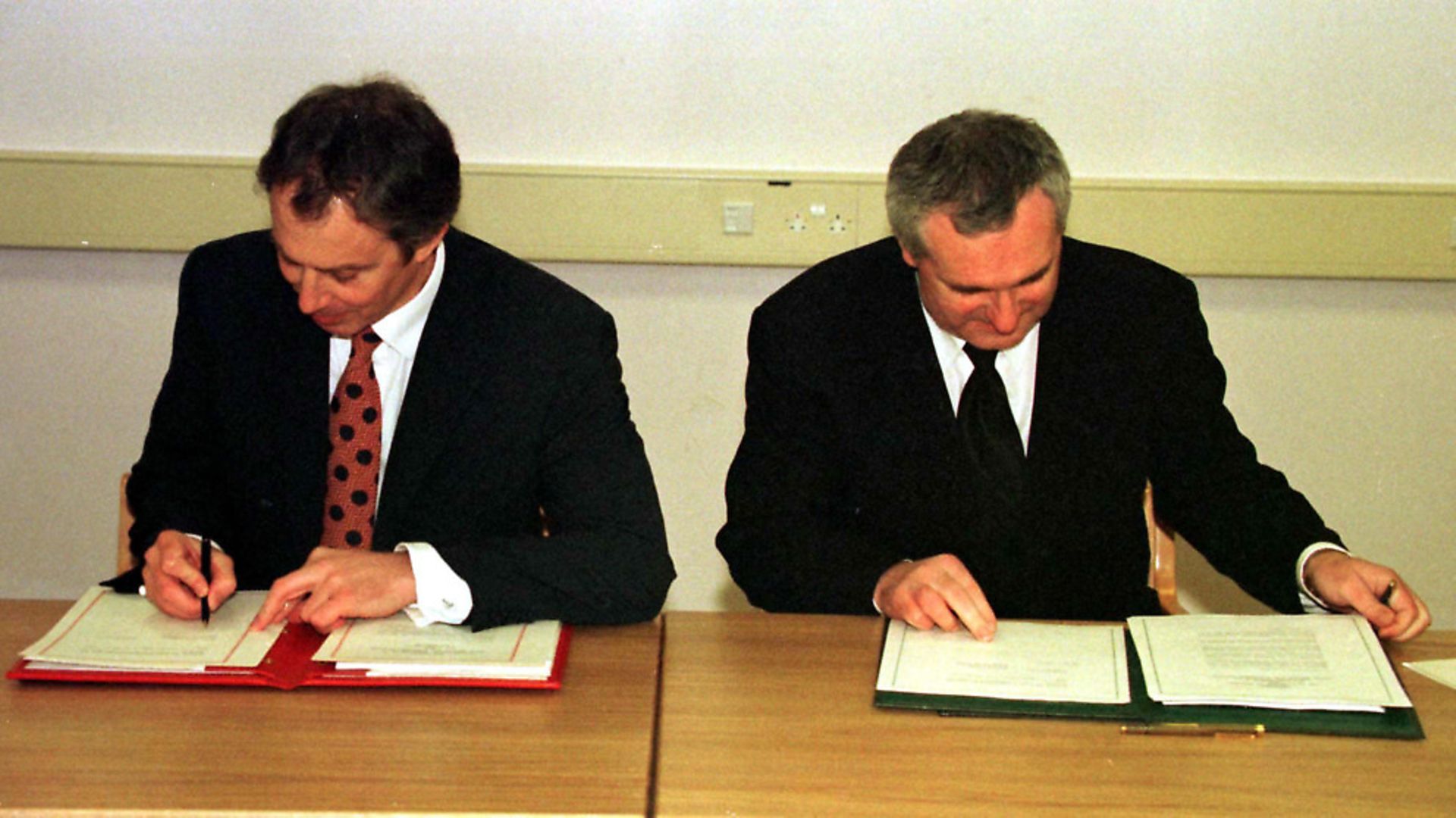 Prime Minister Tony Blair (L) and Taoiseach Bertie Ahern sign the peace agreement today (Friday). They stated that the people of Northern Ireland will decide democratically their own future. Pool photo by by Dan Chung. See PA story ULSTER Talks/PA - Credit: �PA Photos / Topfoto