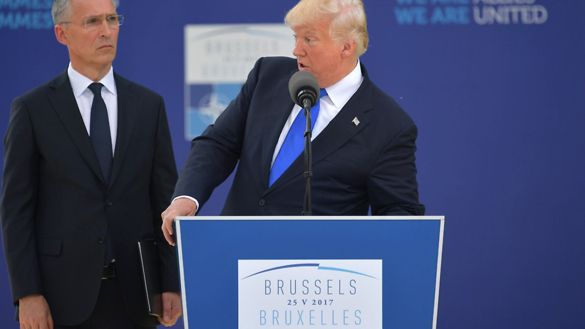 US President Donald Trump (C) delivers a speech next to NATO Secretary General Jens Stoltenberg (L) during the unveiling ceremony of the Berlin Wall monument, during the NATO (North Atlantic Treaty Organization) summit at the NATO headquarters, in Brussels, on May 25, 2017.  / AFP PHOTO / Mandel NGAN        (Photo credit should read MANDEL NGAN/AFP/Getty Images) - Credit: AFP/Getty Images