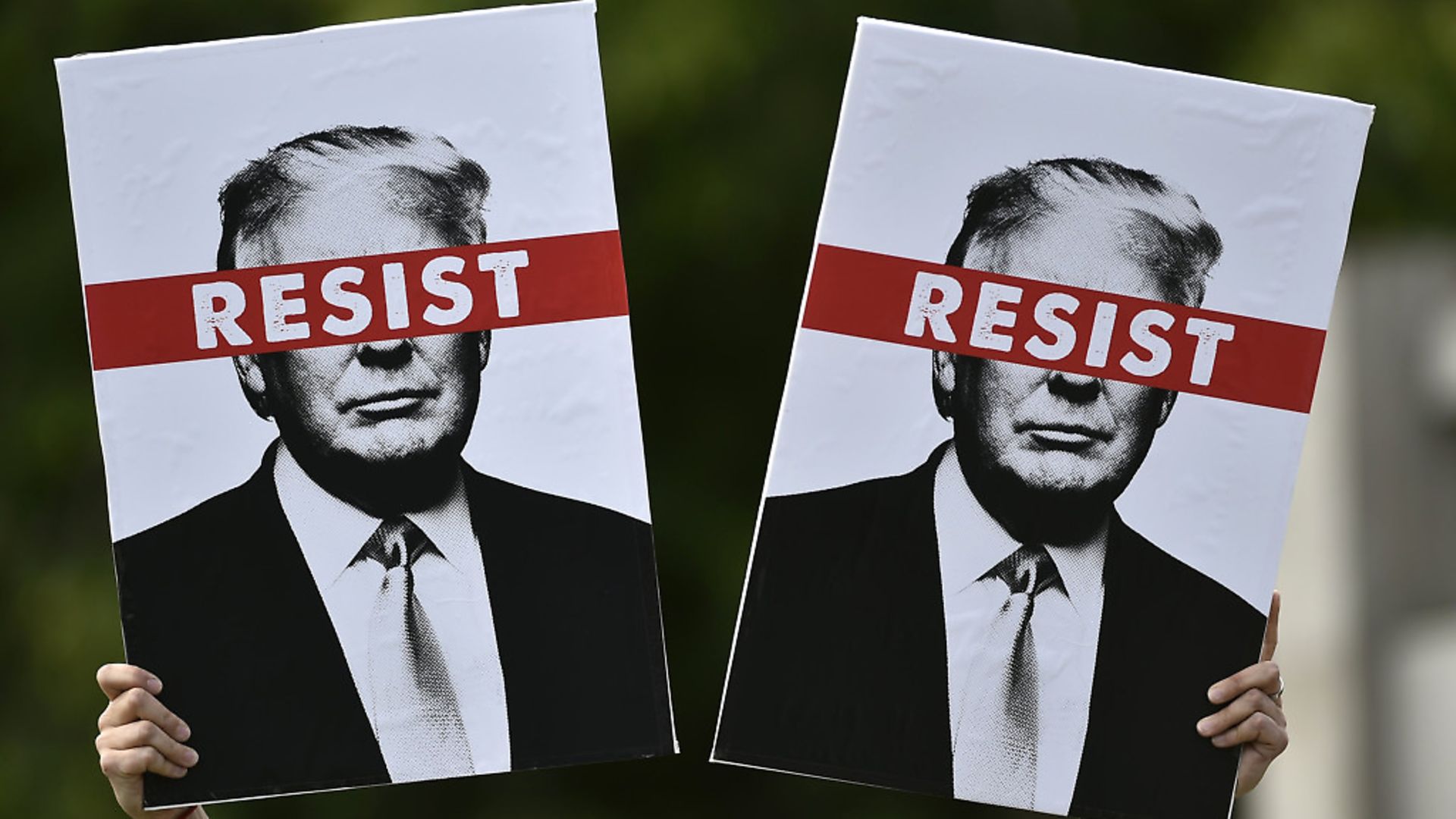 A protestor holds placards prior to the Scotland United Against Trump march through the streets of Edinburgh, Scotland on July 14, 2018 (Photo by NEIL HANNA / AFP/ Getty Images) - Credit: AFP/Getty Images