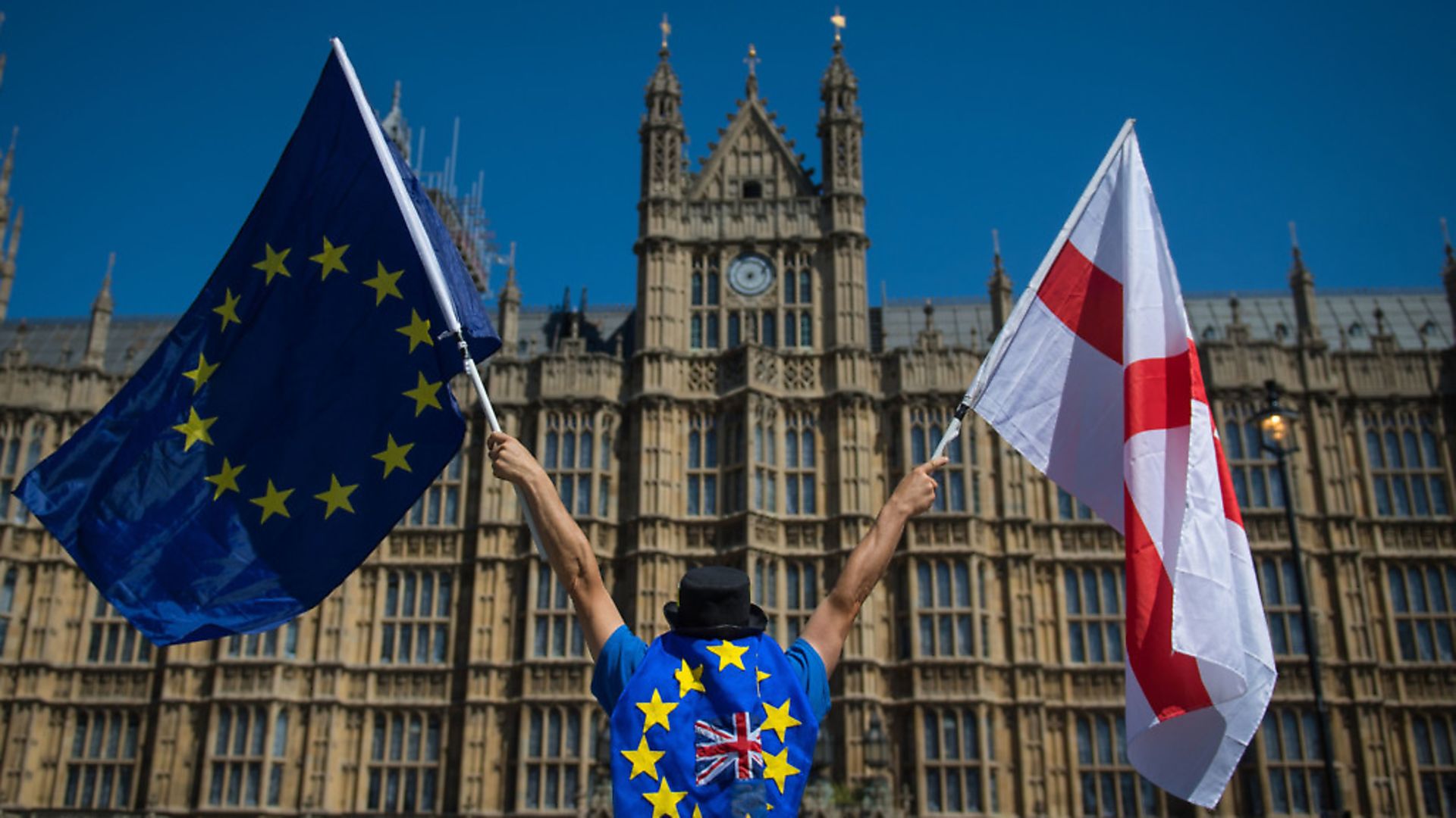 An anti-Brexit demonstrator holding the European Union and England flags outside the Houses of Parliament. Photograph: Dominic Lipinski. - Credit: PA Wire/PA Images