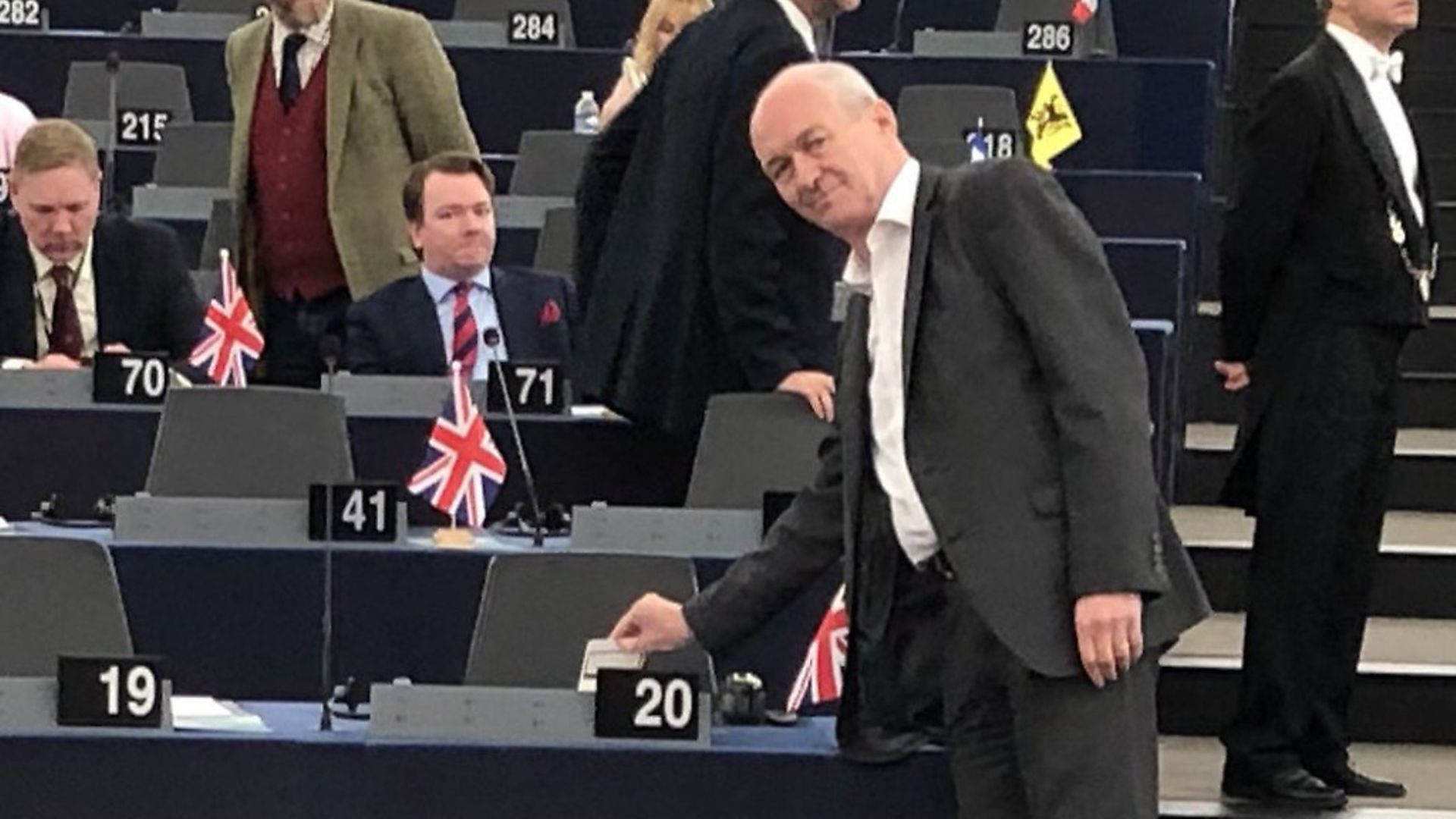 MEP Richard Corbett places a pint-sized Brexit protest on Nigel Farage's table. Photograph: Twitter. - Credit: Archant