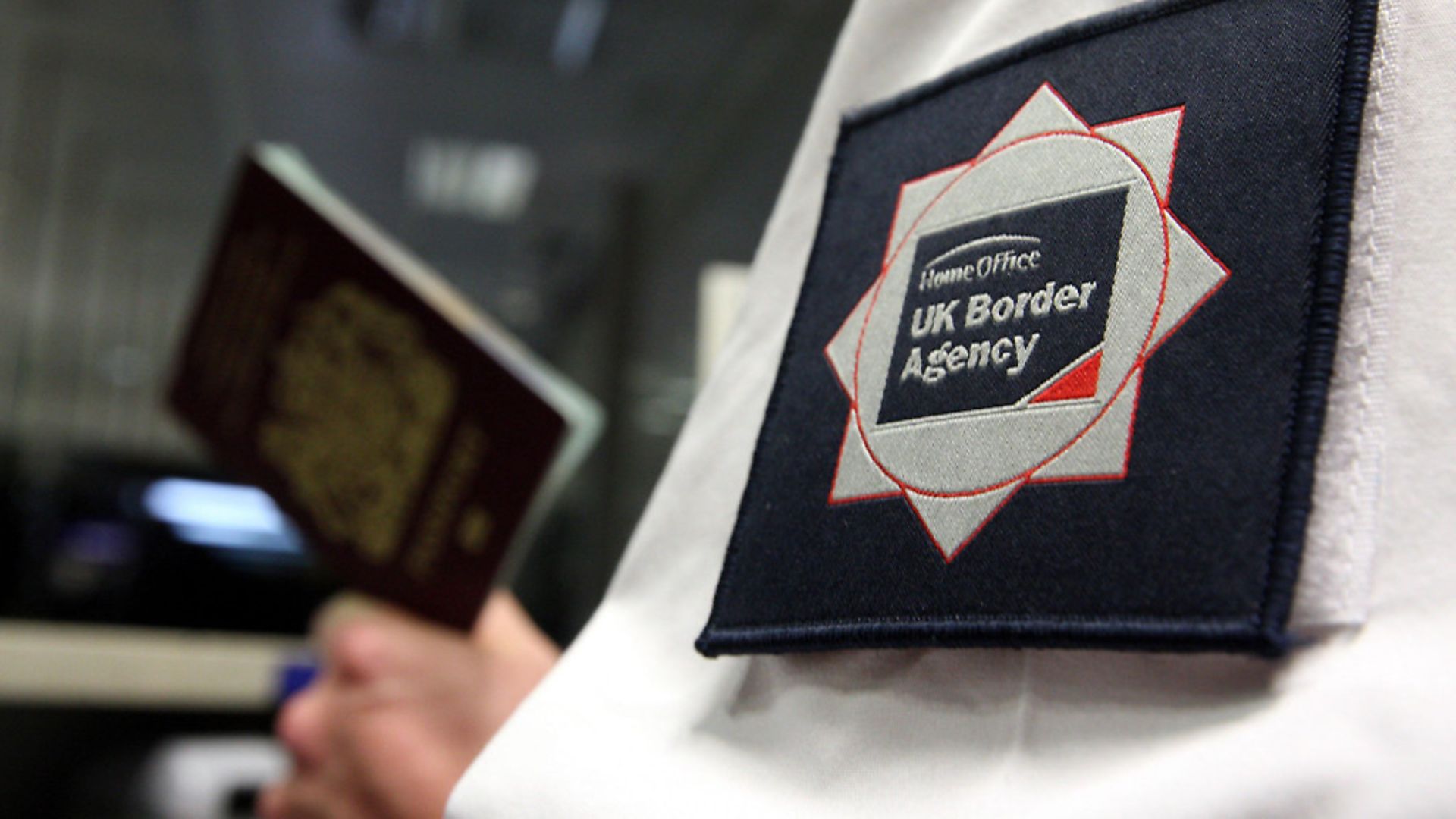 UK Border Agency officer checking a passport in the North Terminal of Gatwick Airport, Sussex. Photograph: Steve Parsons/PA Wire. - Credit: PA