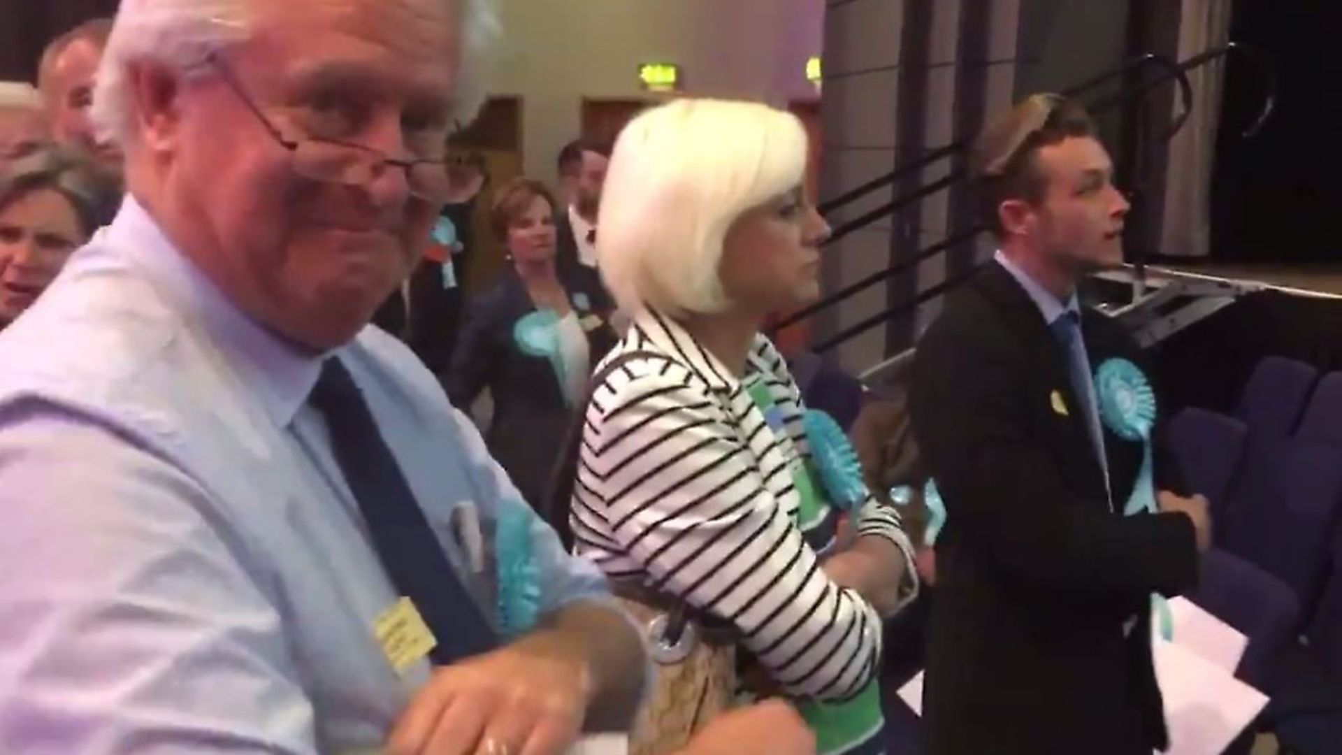 A Brexit Party supporter grins at the camera as others heckle Labour MEP Neena Gill during her acceptance speech. Picture: Twitter/supplied - Credit: Twitter/supplied