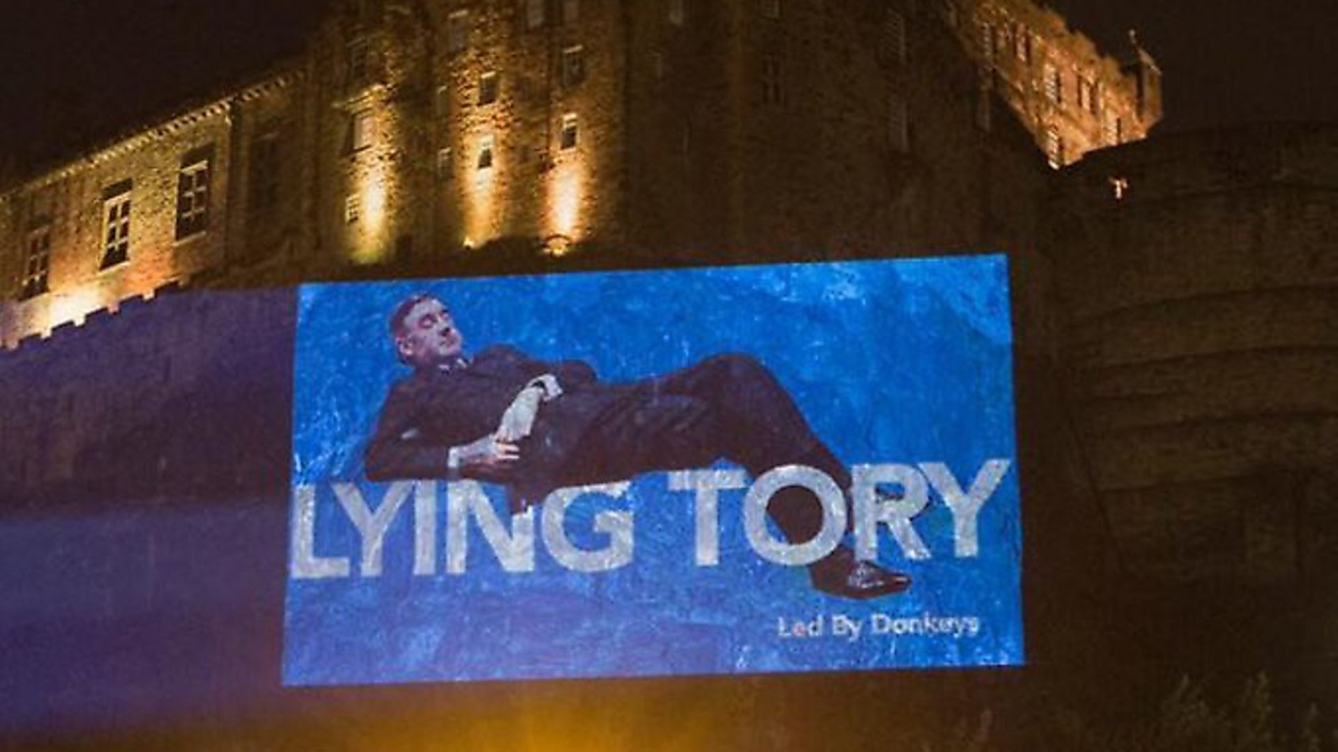 A projection of Jacob Rees-Mogg showing disregard for parliament is projected on to Edinburgh Castle. Photograph: ByDonkeys/Twitter. - Credit: Archant