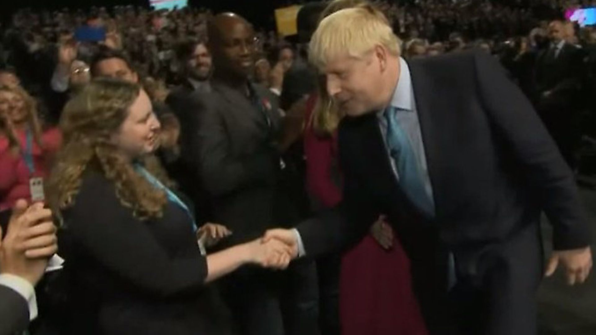 Boris Johnson passes by two black Tory activists. Photograph: BBC. - Credit: Archant