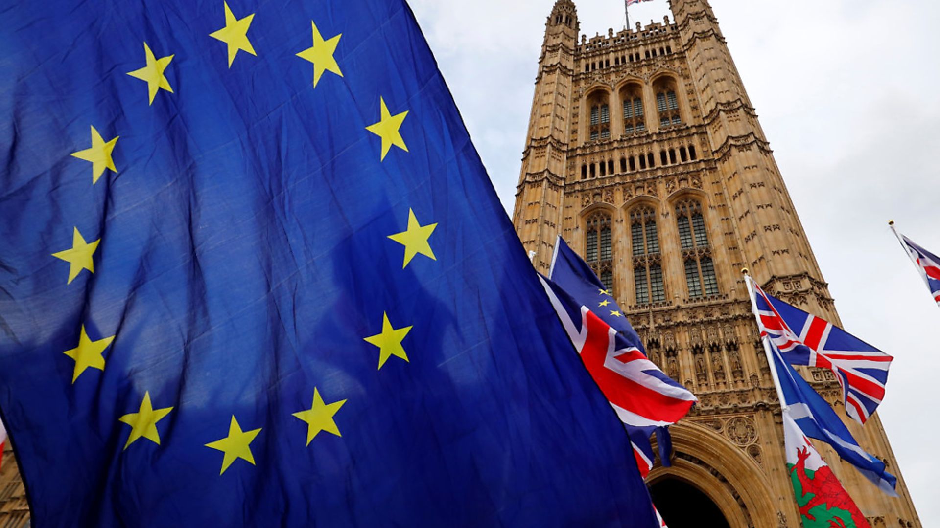 Anti-Brexit activists' EU flags are pictured alongside the union flags of pro-Brexit activists as they demonstrate outside of the Houses of Parliament. (Photo by Tolga Akmen / AFP) - Credit: AFP via Getty Images