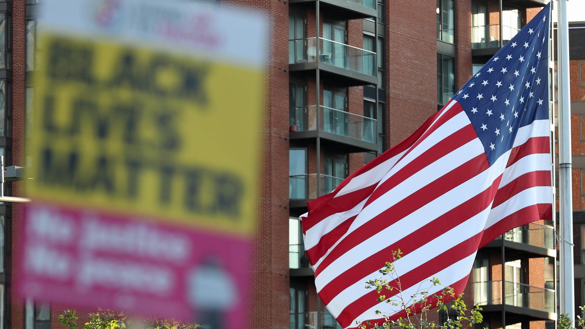 Black Lives Matter placard alongside the American flag - Credit: PA