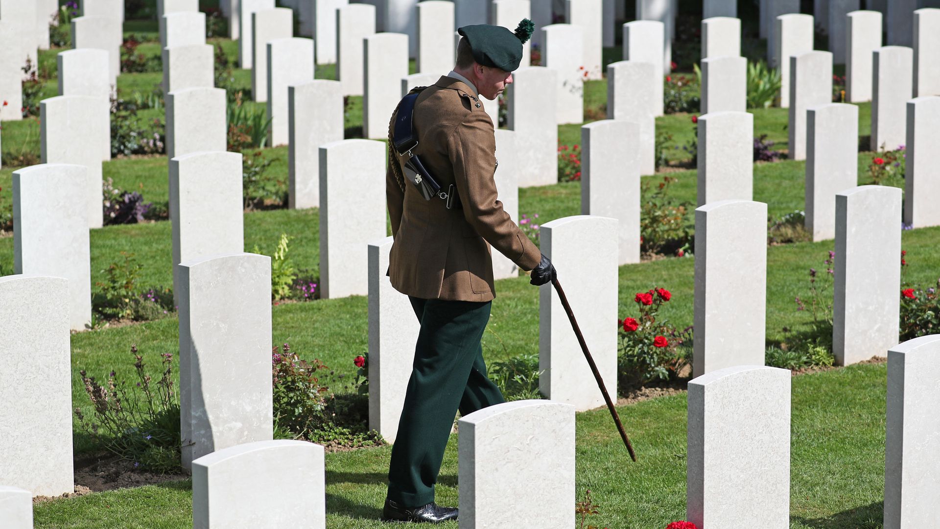 A man in uniform walks past the graves of fallen soldiers during the Royal British Legion's Service of Remembrance, at the Commonwealth War Graves Commission Cemetery, in Bayeux, France, as part of commemorations for the 75th anniversary of the D-Day landings. - Credit: PA