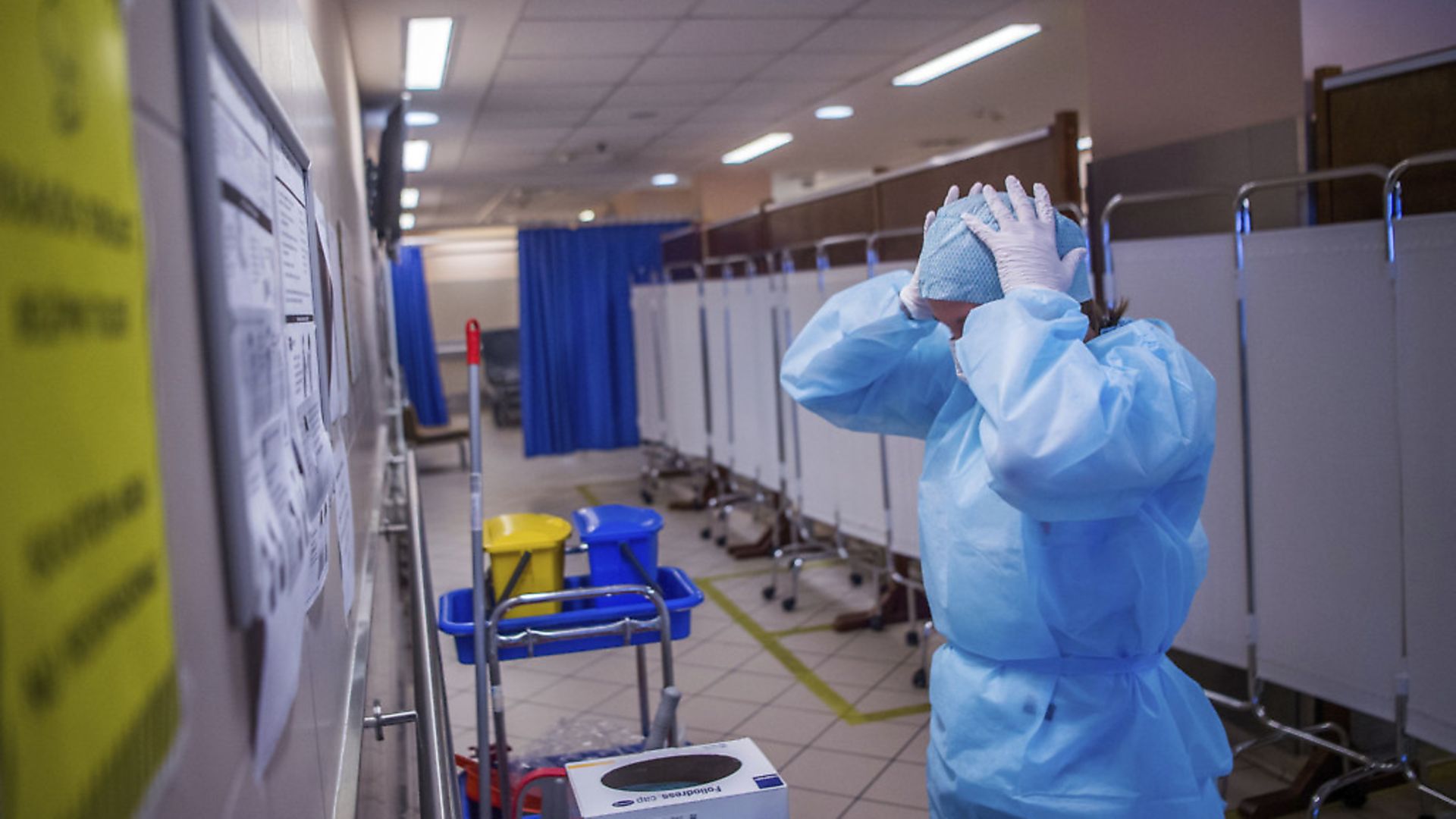 A health worker puts on an protective outfit during the coronavirus outbreak. (Zoltan Balogh/MTI via AP) - Credit: AP