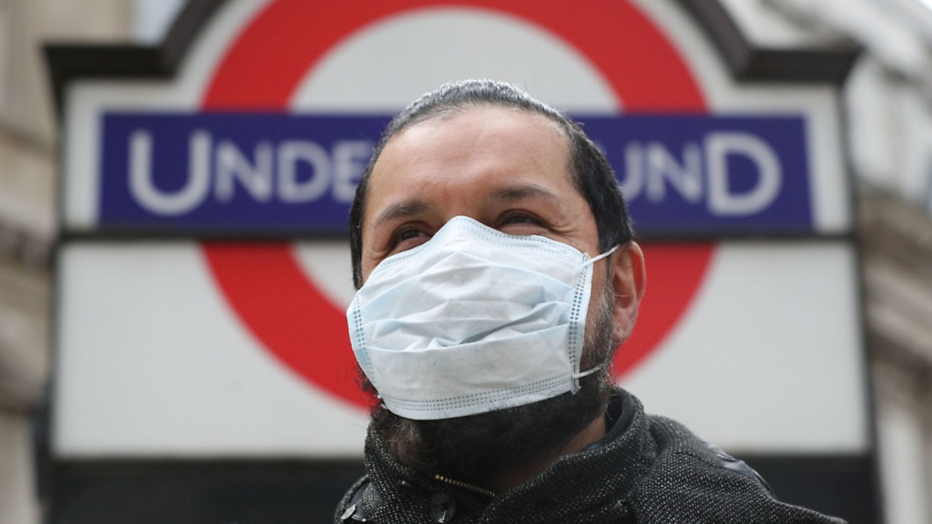 A person wearing a face mask in front of an underground sign in London. Photograph: Jonathan Brady/PA Wire. - Credit: PA