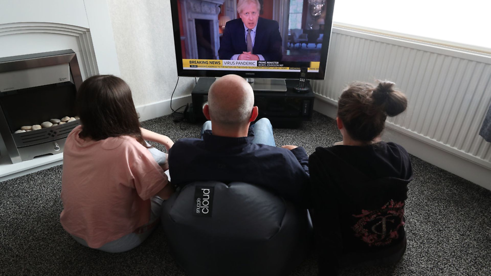 People in a house in Liverpool watch Prime Minister Boris Johnson addressing the nation about coronavirus (COVID-19) from 10 Downing Street. Photograph: Peter Byrne/PA Wire. - Credit: PA