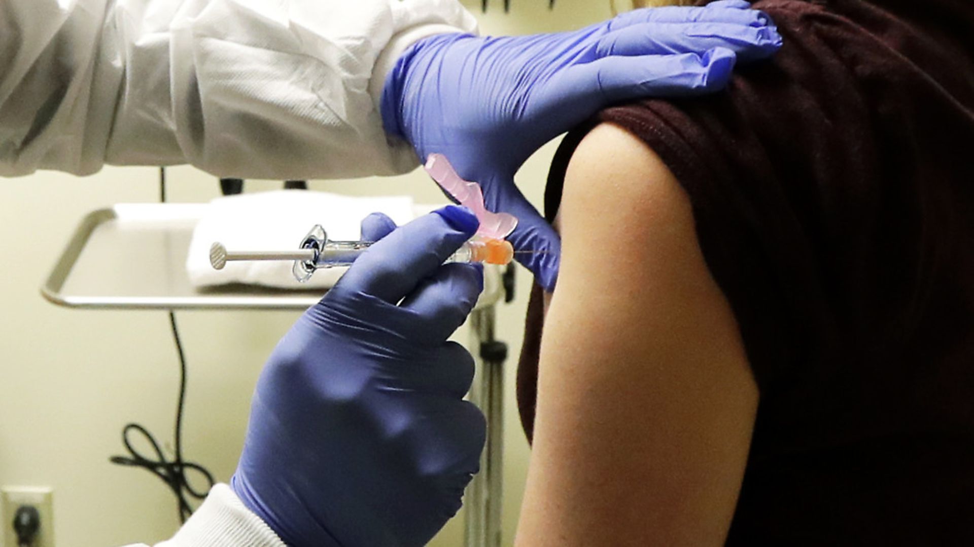 Pharmacist Michael Witte, left, gives Rebecca Sirull, right, a shot in the first-stage safety study clinical trial of a potential vaccine for COVID-19, the disease caused by the new coronavirus at the Kaiser Permanente Washington Health Research Institute in Seattle. (AP Photo/Ted S. Warren) - Credit: AP