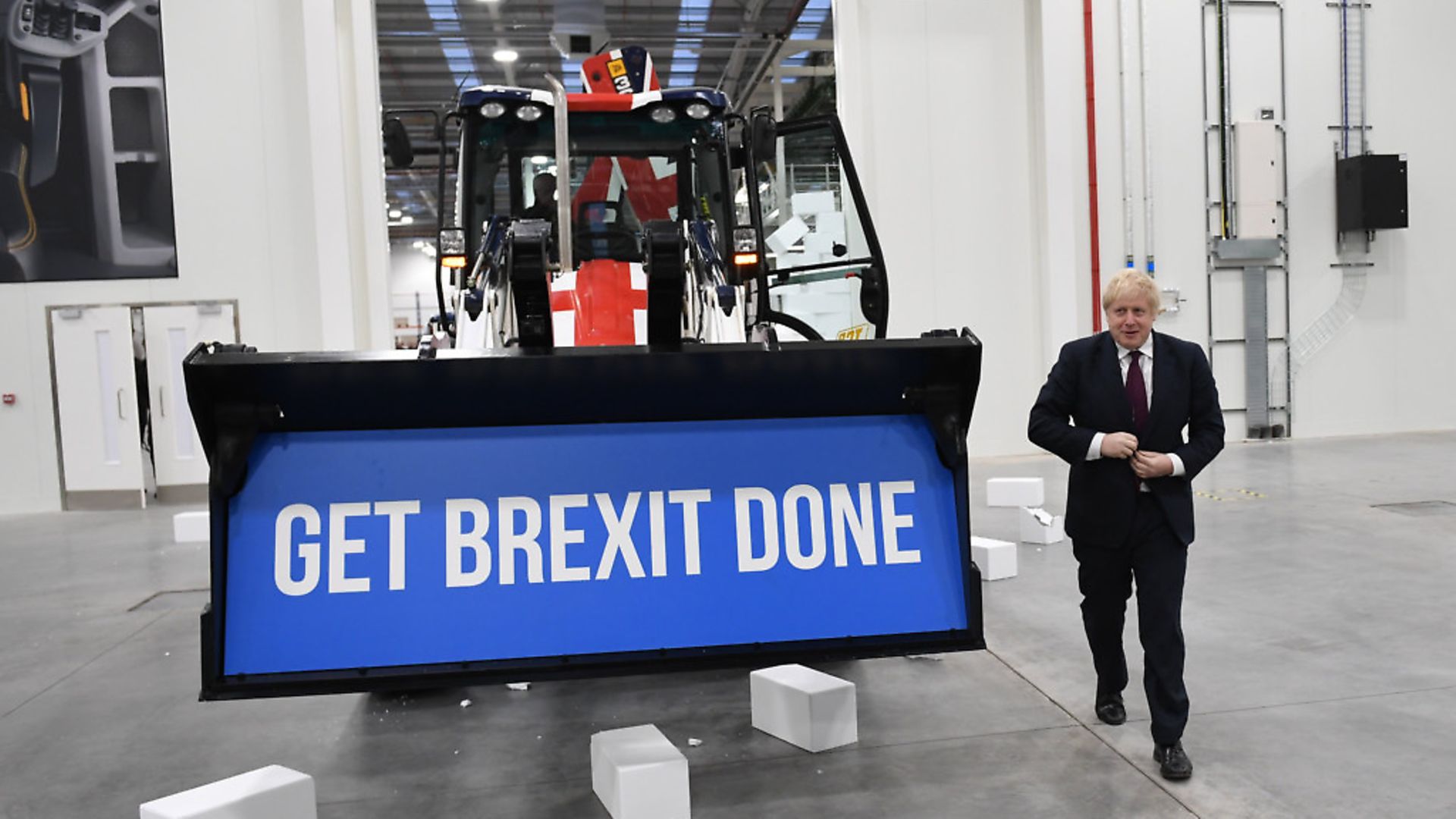 Prime Minister Boris Johnson walks away after driving a Union flag-themed JCB, with the words "Get Brexit Done" inside the digger bucket. Photograph: Stefan Rousseau/PA. - Credit: PA