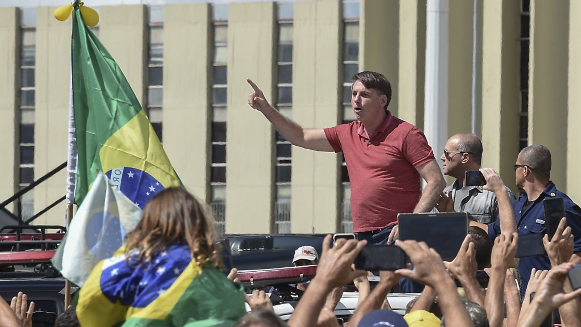 Brazilian President Jair Bolsonaro speaks after joining his supporters who were taking part in a motorcade to protest against quarantine and social distancing measures to combat the new coronavirus outbreak. (Photo by EVARISTO SA / AFP) (Photo by EVARISTO SA/AFP via Getty Images) - Credit: AFP via Getty Images