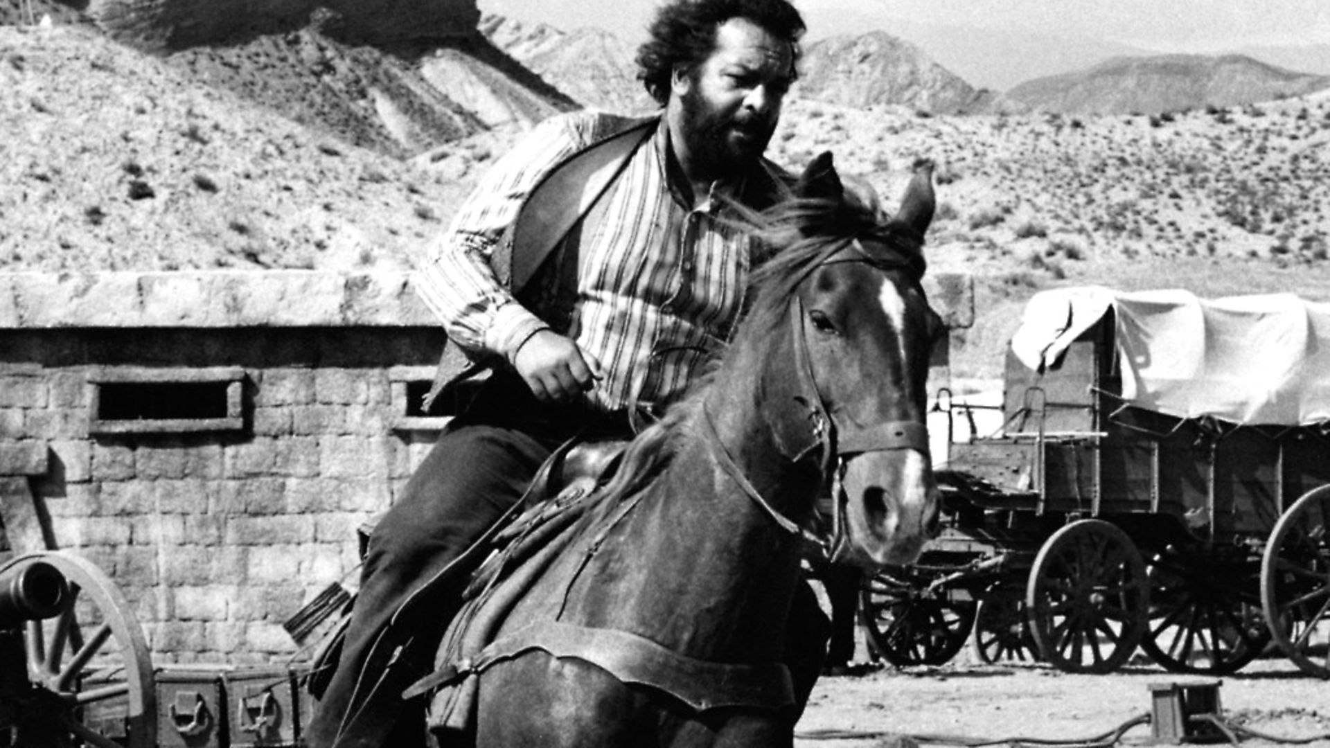 Italian actor and swimmer Bud Spencer (Carlo Pedersoli) riding a horse in the film A Reason to Live. 1972 (Photo by Mondadori Portfolio by Getty Images) - Credit: Mondadori via Getty Images