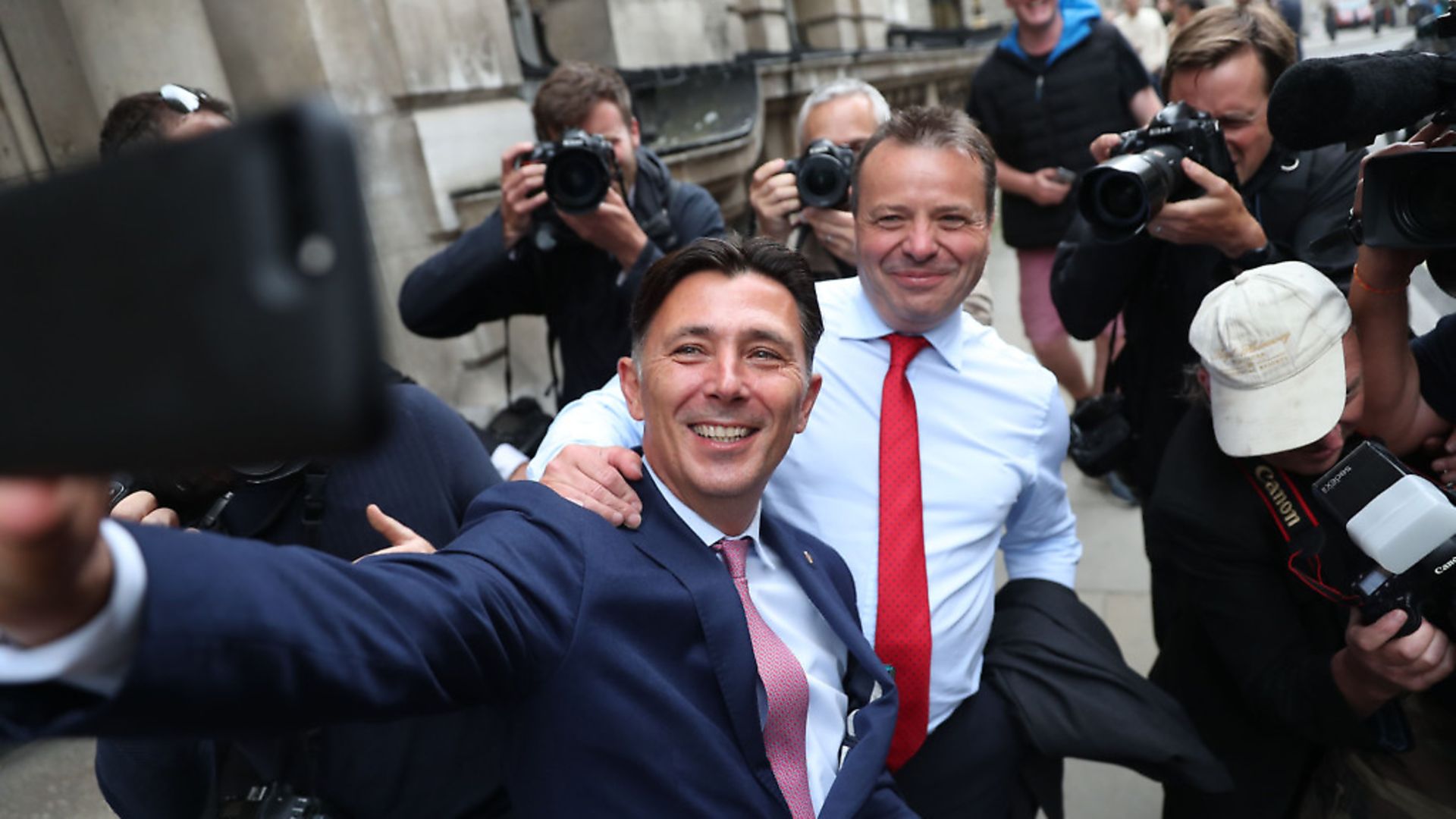 Brexit campaign donor and businessman Arron Banks (CR) and Leave.EU campaigner Andy Wigmore (CL) take a selfie photograph with members of the media in the background as they leave Portcullis House after giving evidence to Parliament's Digital, Culture, Media and Sport (DCMS) Committee. (DANIEL LEAL-OLIVAS/AFP via Getty Images) - Credit: AFP via Getty Images