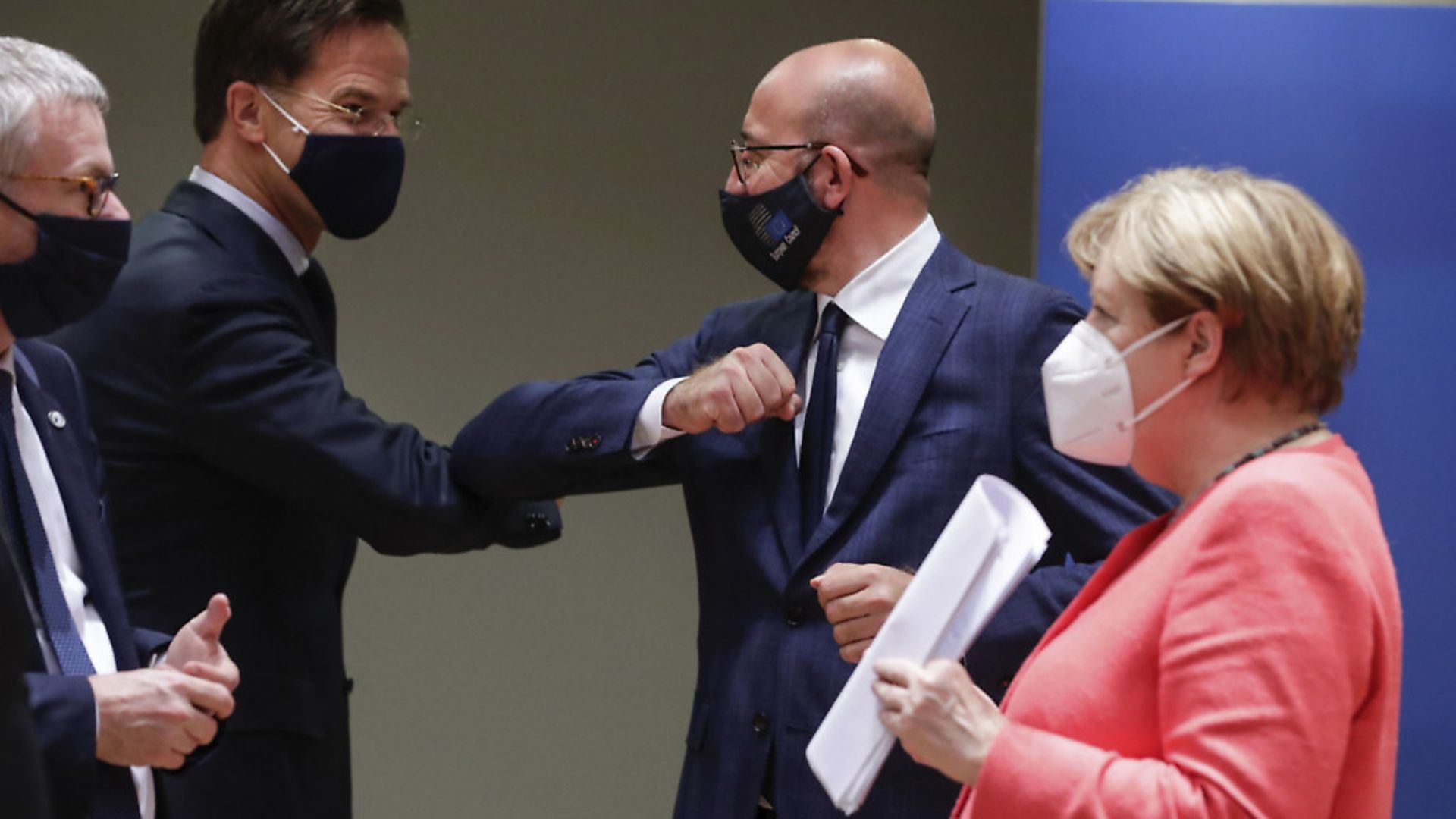 Dutch Prime Minister Mark Rutte, center left, elbow bumps with European Council President Charles Michel, center right, as German Chancellor Angela Merkel, right, walks by during a round table meeting at an EU summit in Brussels. (Stephanie Lecocq, Pool Photo via AP) - Credit: AP