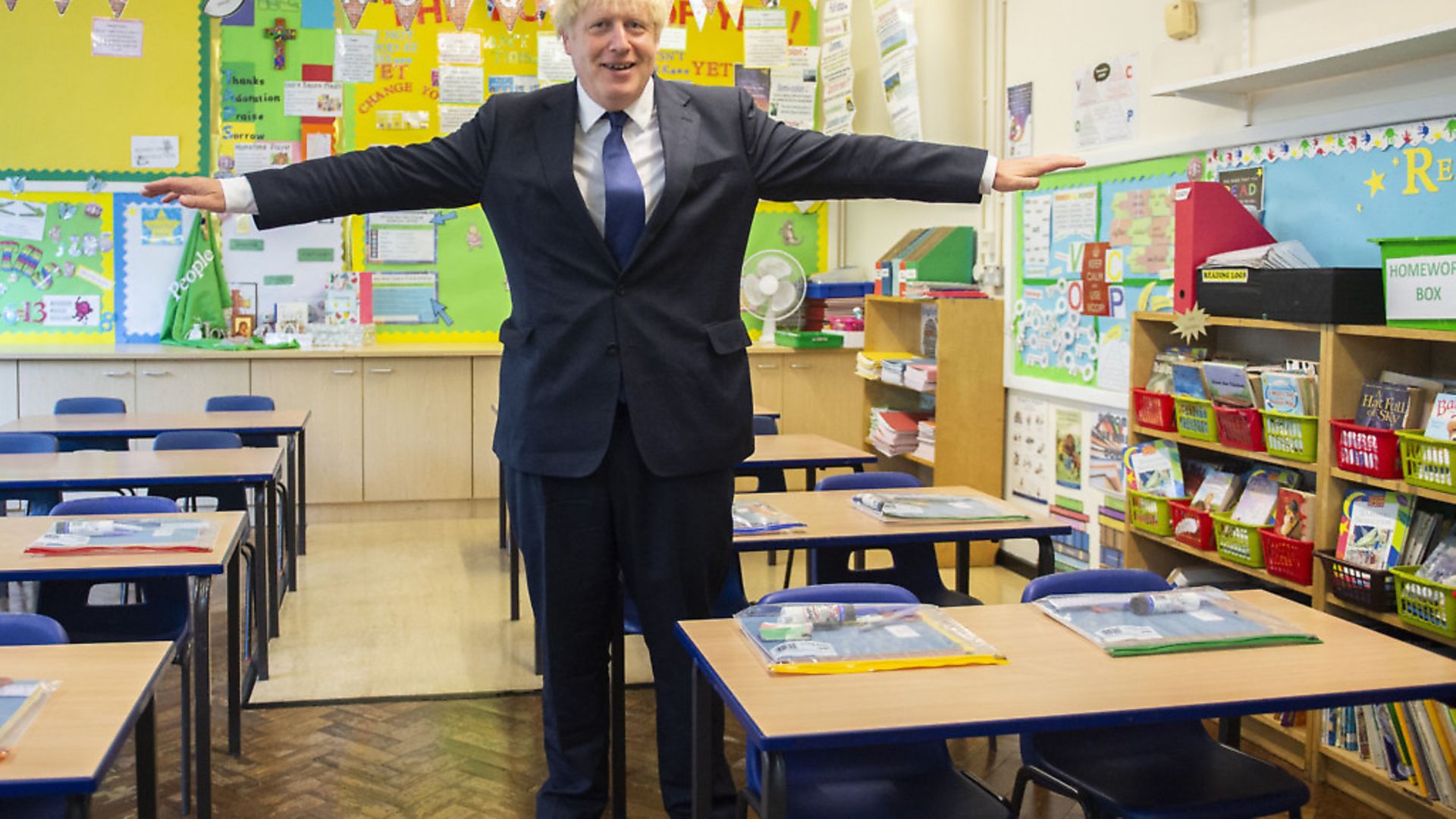 Prime minister Boris Johnson holds his arms out like an aeroplane, demonstrating the two metre distancing rule, during his visit to St Joseph's Catholic Primary School in Upminster. Photo: Lucy Young/Evening Standard/PA Wire - Credit: PA