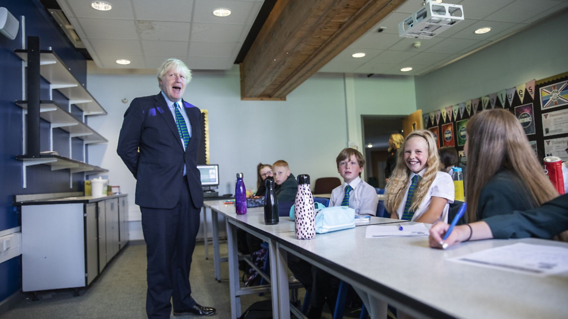 Prime Minister Boris Johnson, wearing the school tie he was presented with on arrival, speaks to a class of year 7 pupils on their first day back at school. (Photo by Jack Hill - WPA Pool/ Getty Images) - Credit: Getty Images