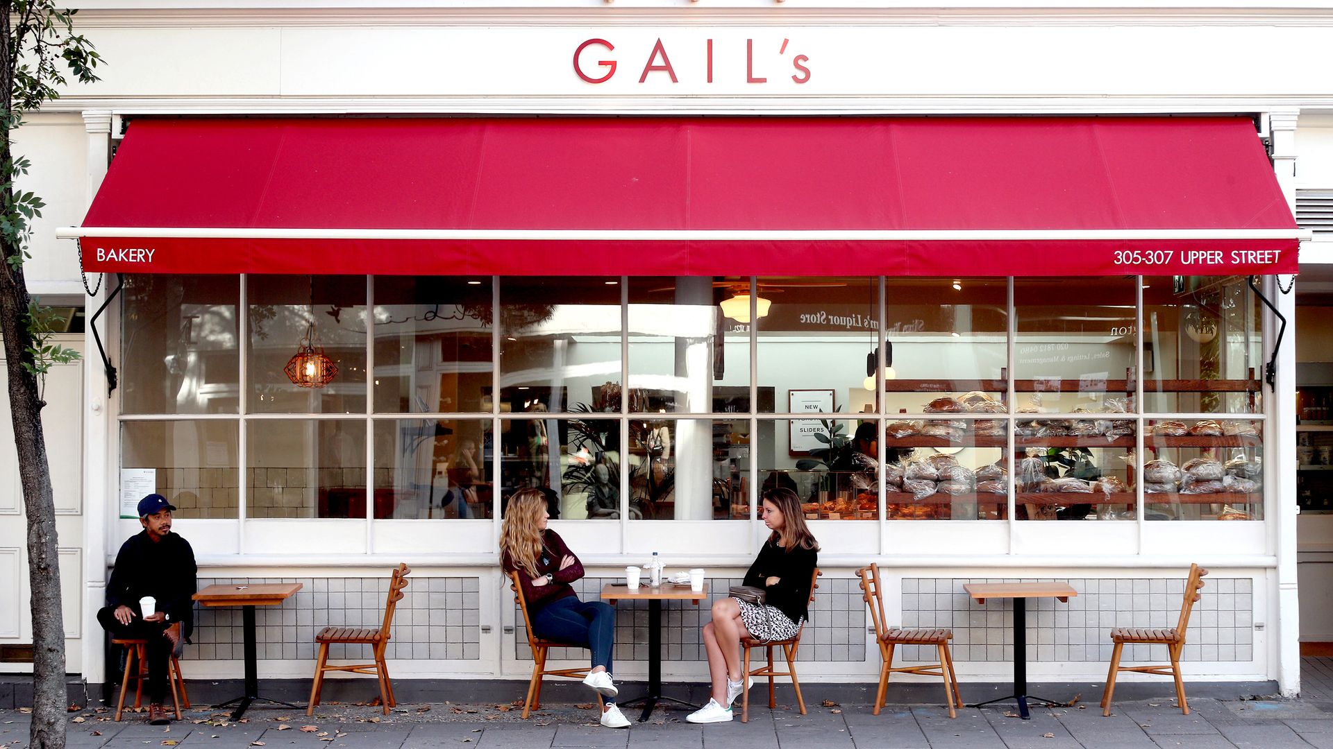Customers observe social distancing as they sit outside a branch of Gail's bakery. - Credit: PA