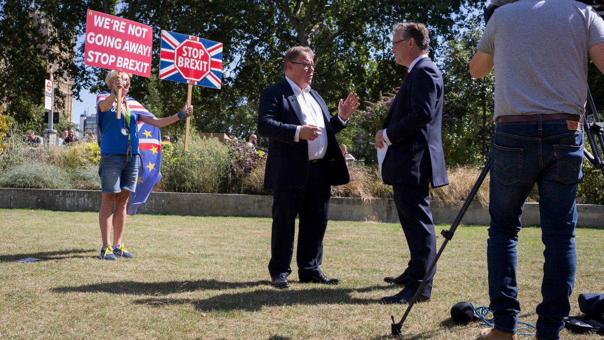 As a Remain protestor holds up placards behind him, Brexiteer MP Mark Francois is interviewed on College Green in August 2019 - Credit: In Pictures via Getty Images