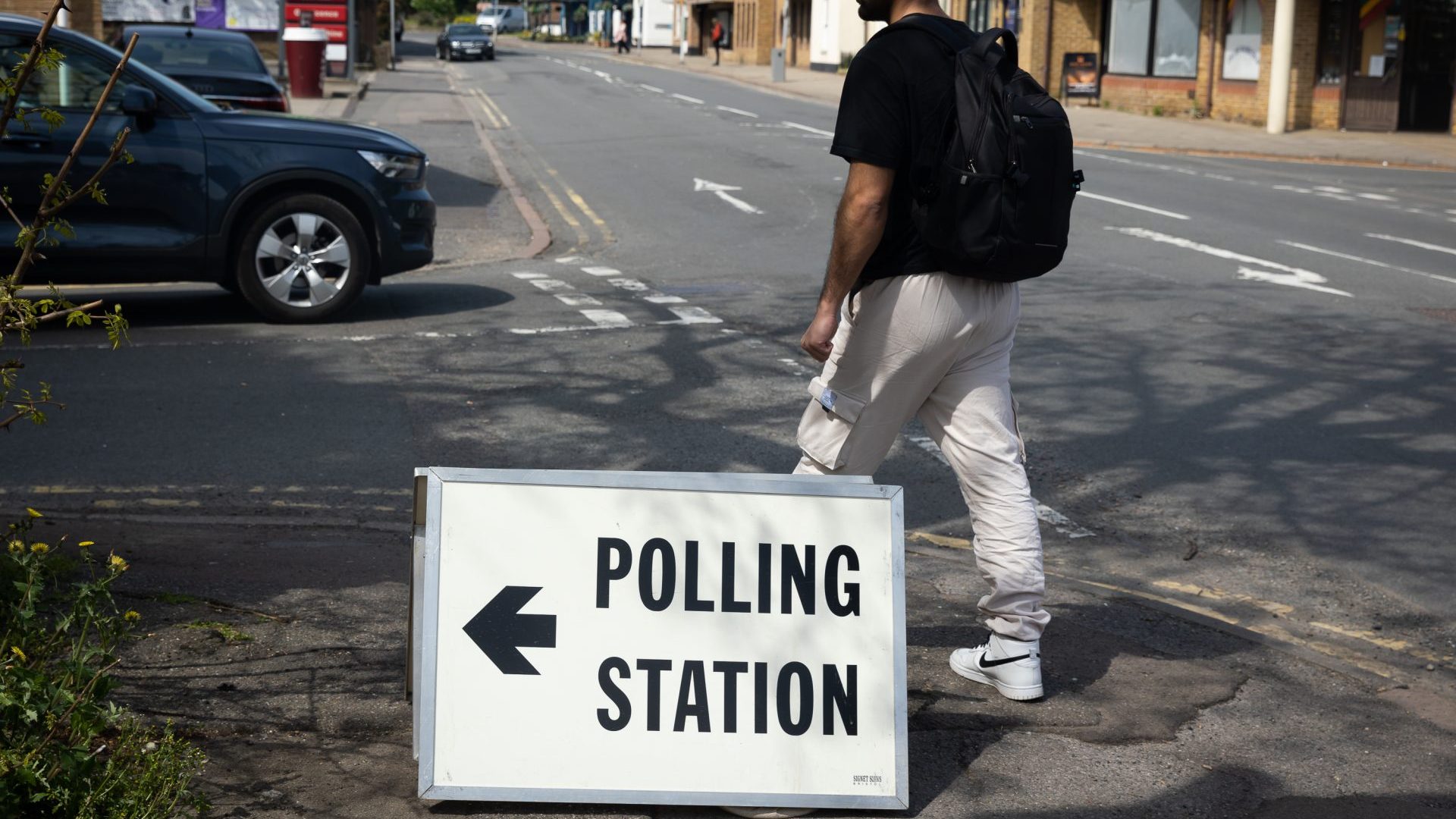 A man walks past a polling station sign in Egham, as members of the public go to cast their votes (Photo by Tejas Sandhu/SOPA Images/LightRocket via Getty Images)