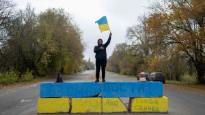A resident of Kherson celebrates the liberation of the city in November 2022 at a former Russian checkpoint. Photos: Bulent Kilic/AFP/Getty