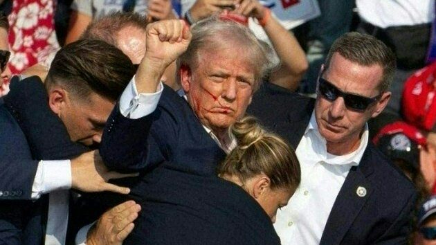 Republican candidate Donald Trump is seen with blood on his face surrounded by secret service agents as he is taken off the stage at a campaign event in Pennsylvania (Photo by REBECCA DROKE/AFP via Getty Images)