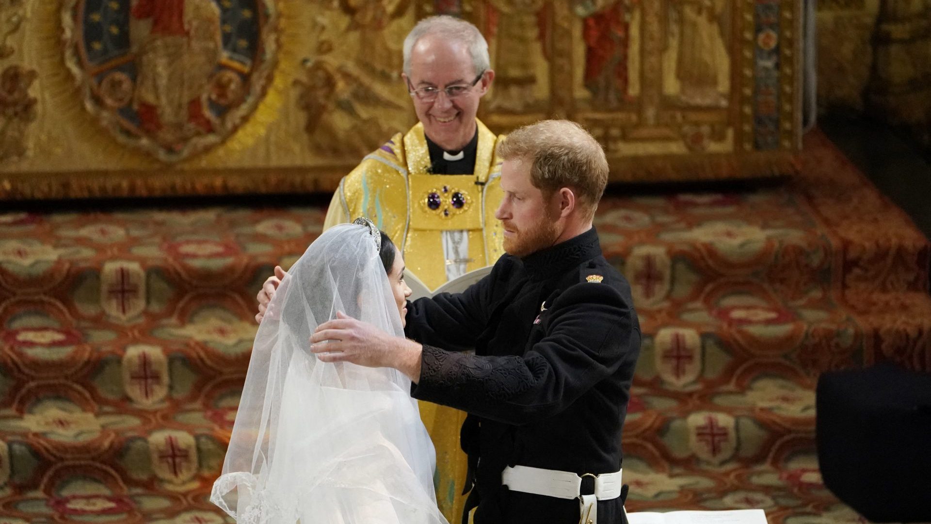 Prince Harry removes the veil of Meghan Markle as they stand at the altar together before Archbishop of Canterbury Justin Welby (Photo by OWEN HUMPHREYS/POOL/AFP via Getty Images)