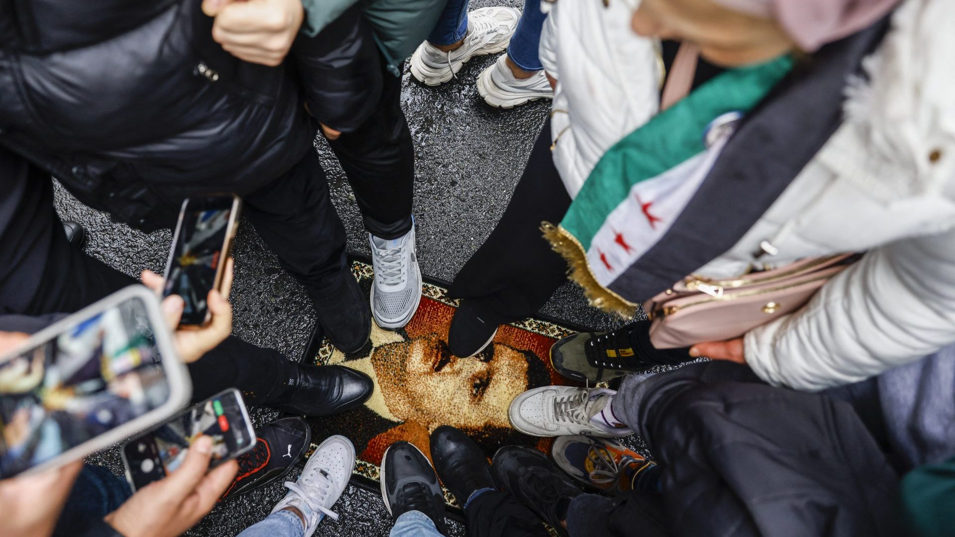 Demonstrators trample a carpet with a design showing president Bashar al-Assad during a protest outside the Syrian consulate in Istanbul. Photo: Kemal Aslan/AFP/Getty