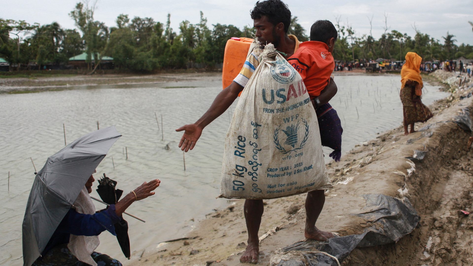 A Rohingya refugee carrying a USAID bag reaches out to a woman in Bangladesh as they flee violence in neighbouring Myanmar. Donald Trump has recently announced a 90-day freeze on funding for foreign aid projects.
Photo: Emrul Kamal/AFP/Getty