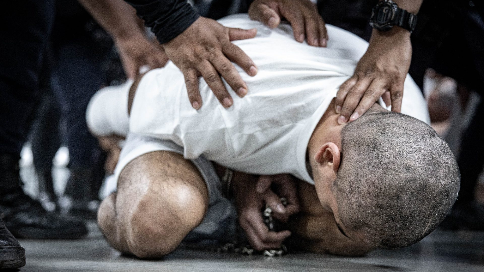A man – one of more than 200 Venezuelans and Salvadorans deported from the US by the Trump administration earlier this month – is restrained by guards at CECOT in Tecoluca, El Salvador. Photo: Salvadoran Government/Getty