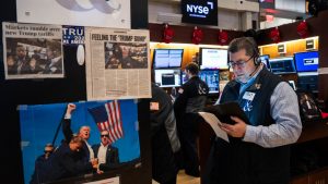 Traders work next to images of President Donald Trump on the floor of the New York Stock Exchange during morning trading. Photo: Adam Gray/Getty Images