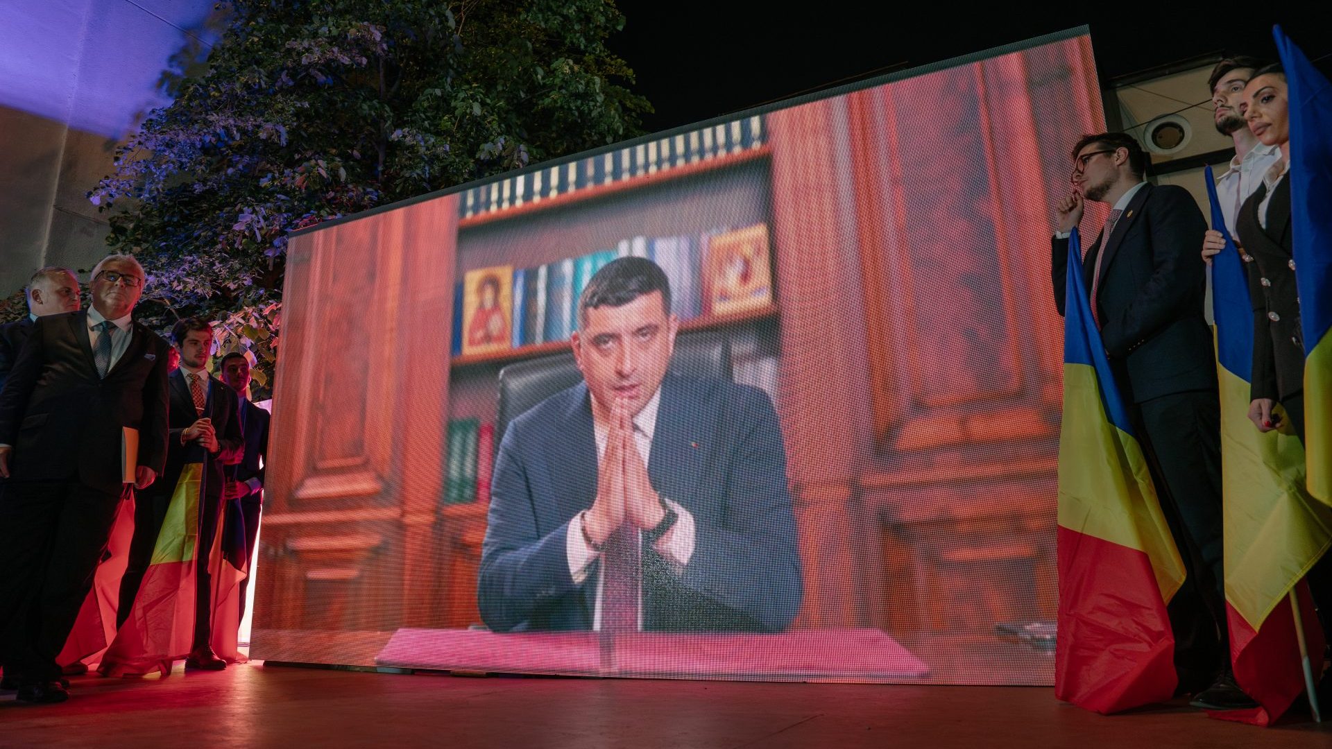 Presidential candidate George Simion is shown on a screen addressing his supporters at his campaign headquarters. Photo: Andrei Pungovschi/Getty Images