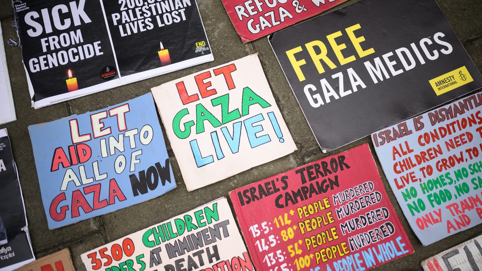 A selection of placards are seen on the pavement as a group of protesters demonstrate outside the Foreign Office. Photo: Leon Neal/Getty Images