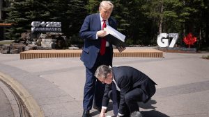 rime Minister Sir Keir Starmer picks up UK US trade deal papers dropped by US President Donald Trump before speaking to the media at the G7 Leaders' Summit. Photo: Stefan Rousseau-Pool/Getty Images