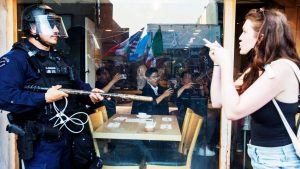 Diners in a restaurant look on as a protester gestures to a police officer during a protest in the California city.
Images: Ringo Chiu/AFP/Getty