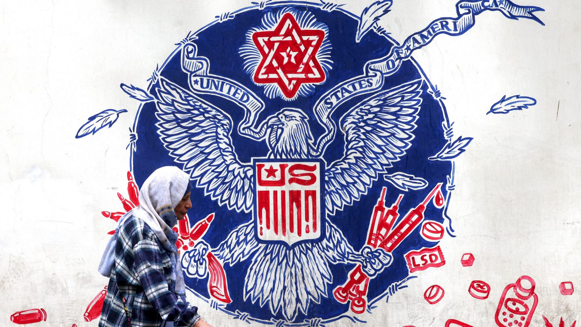 A mural on the wall of the former US embassy in Tehran depicts a parody of the Great Seal of the US, featuring drugs and firearms, and a Star of David. Image: Atta Kenare/AFP/Getty