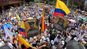 People wearing white t-shirts and holding national flags participate in the so-called "Silent March" to show support for the health of Senator Miguel Uribe Turbay. Photo: AIME SALDARRIAGA / AFP