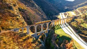 The Train Jaune crosses an arched bridge over a deep gorge in the Pyrenees-Orientales region of France. Image: Artur Debat/Getty