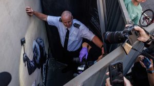 Security try and block a view as forensic police photographers arrive to take photographs of what is believed to be a new mural by the street artist Banksy. Photo: Dan Kitwood/Getty Images
