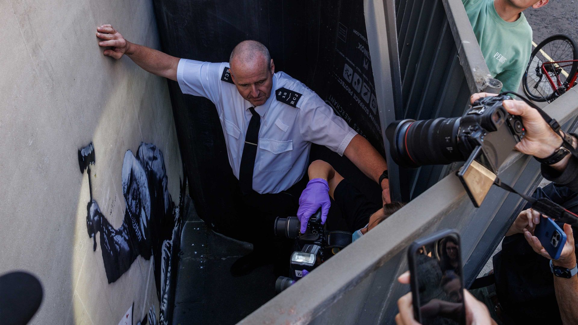 Security try and block a view as forensic police photographers arrive to take photographs of what is believed to be a new mural by the street artist Banksy. Photo: Dan Kitwood/Getty Images