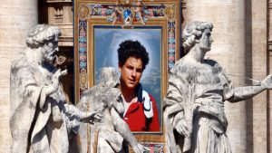 A tapestry featuring Carlo Acutis hangs from a balcony at St Peter’s. IMAGE: Franco Origlia/Getty