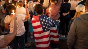 An attendee wears a U.S. flag during a candlelight vigil for Turning Point USA Founder Charlie Kirk. Photo: David Ryder/Getty Images