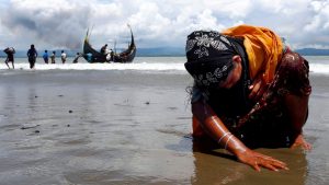 A Rohingya refugee touches the sand after crossing the Bangladesh-Myanmar border by boat, September 2017. Image: Danish Siddiqui/Reuters