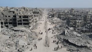 Exhausted Palestinians walk amid the destruction in Gaza City in the northern Gaza Strip on October 11, a day after the ceasefire took effect. Image: AFP/Getty