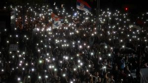 Protesters light up their smartphones on the second night of a blockade of Serbia’s public broadcaster RTS in Belgrade, April 2025. Image: Oliver Bunic/str/AFP/Getty