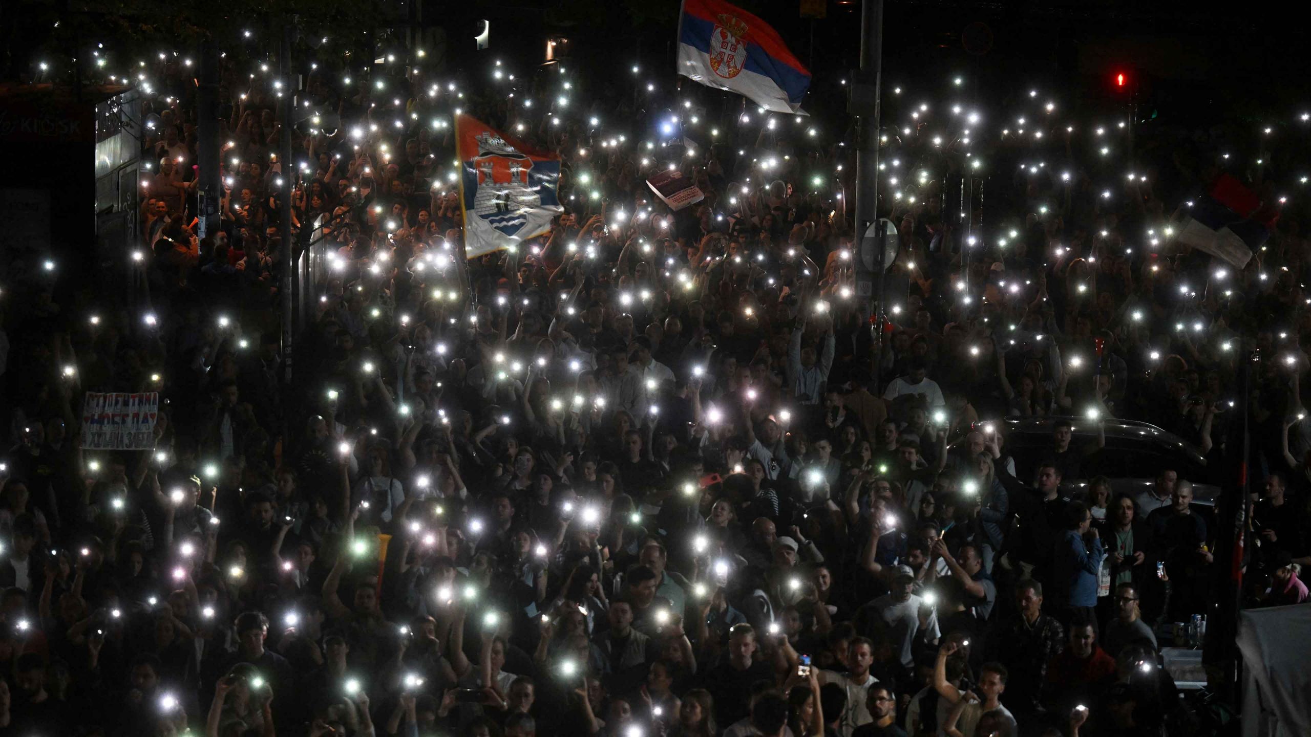 Protesters light up their smartphones on the second night of a blockade of Serbia’s public broadcaster RTS in Belgrade, April 2025. Image: Oliver Bunic/str/AFP/Getty