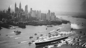 A huge cordon of tugs accompanies the new superliner SS United States past the New York skyline, June 23, 1952. Credit: Bettmann